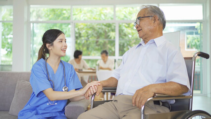 Wall Mural - An Asian nurse talking to a group of old elderly patient or pensioner people smiling, relaxing, having fun together in nursing home. Senior lifestyle activity recreation. Retirement. Health care