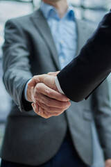 two diverse professional business men executive leaders shaking hands at office meeting