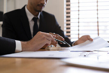 Business meeting, two caucasian, asian group man use pen, brainstorm analyzing on graph data of cost plan or document, paperwork and discussing in board room on table. People working conference room.