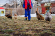 © Cavan Images - Bottom-half of child in Taekwondo uniform with chickens in yard