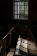 Light filtering through a church window with shadows on the pew