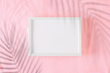 Sticker - Summer concept. Flat lay photo of tropical leaf shadows on pink sandy background and white frame in the middle. Minimal vacation idea.