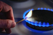 © Oleksandr - A man lights a gas stove with a match. The gas stove is lit by a match, close-up.