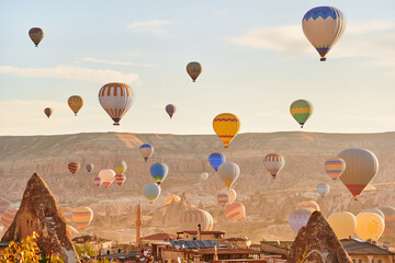 Landscape of fabulous Kapadokya. Colorful flying air balloons in sky at sunrise in Anatolia. Vacations in beautiful destination in Goreme, Turkey