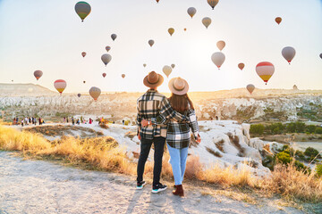 Couple travelers vacations together in beautiful destination in Goreme, Turkey. Fabulous Kapadokya with flying air balloons at sunrise, Anatolia