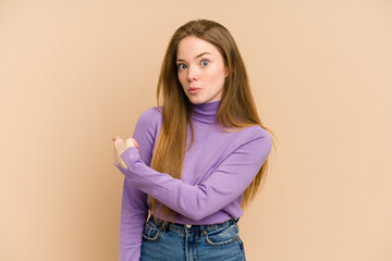 Wall Mural - Young redhead woman cut out isolated smiling and pointing aside, showing something at blank space.