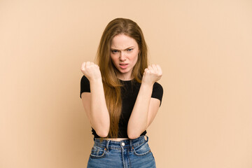 Wall Mural - Young redhead woman cut out isolated showing fist to camera, aggressive facial expression.