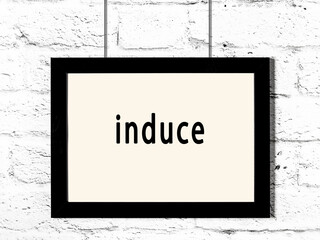 Wall Mural - Black frame hanging on white brick wall with inscription induce