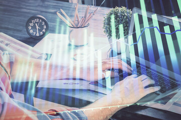Poster - Double exposure of stock graph with businessman typing on computer in office on background. Concept of hard work.