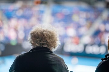 Wall Mural - elderly tennis fan watching a farm in a wheelchair at the australian open