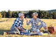 © pucko_ns - Mature couple sitting on blanket in nature and make picnic. She feed old man with piece of food and smile