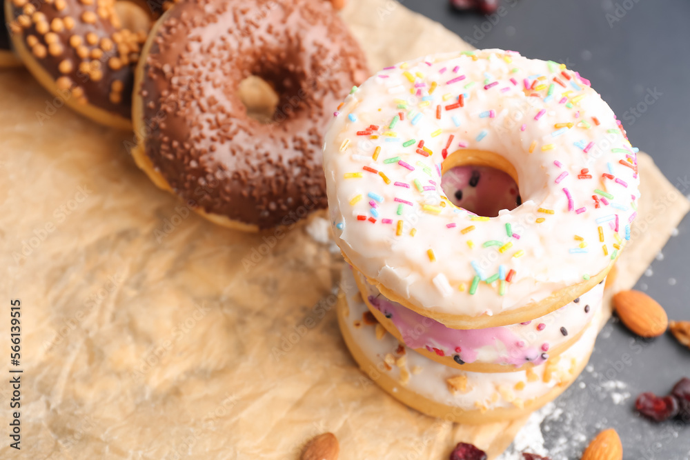 Sheet of baking paper with tasty donuts, closeup