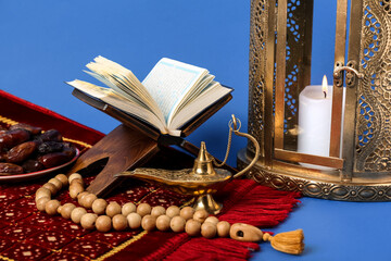 Wall Mural - Aladdin lamp, prayer beads, Koran and Muslim lantern for Ramadan on blue background