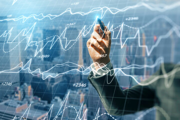 Poster - Close up of businessman hand pointing at creative forex business chart on blurry city background. Trade, finance and digital marker concept. Double exposure.