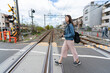 © PR Image Factory - side view with full length asian Japanese female traveler walking across railway crossing in uji city Kyoto japan on a sunny day in spring