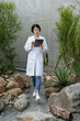 © PR Image Factory - full length of asian Korean woman botanist using computer pad while working in the desert botanic garden with stones