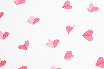 Wall Mural - Pink hearts cut out from white paper. Festive background for valentine's day.