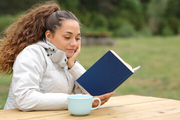 Hiker reading a book in a table