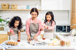 © Art_Photo - Portrait of enjoy happy love asian family mother and little toddler asian girl daughter child having fun cooking together with dough for homemade bake cookie and cake ingredient on table in kitchen