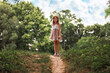 © _KUBE_ - Happy childhood. Cute little schoolgirl girl in a straw hat and dress posing on a slope. Park and sky at the background. School holidays. The concept of freedom and summertime
