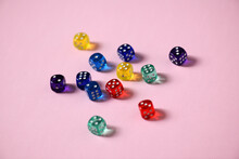 Close-up Of Colorful Dice Over Pink Background