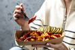 © Надія Коваль - Female hands holding box French fries baked with cheddar cheese, pickle and sausages, Fast food take away. Top view, copy space