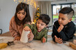 © Cultura Creative - Kids preparing Christmas cookies in kitchen