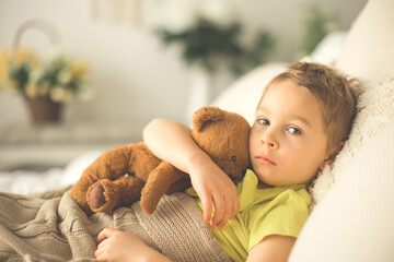 Canvas Print - Cute little preschool boy with his pet dog, playing together in bed