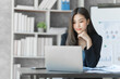 © M+Isolation+Photo - Beautiful Asian female bookkeeper doing online accounting with laptop in private accounting office, balance sheet and stock market statistics.