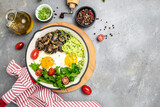 Fototapeta Kuchnia - Closeup of tasty fried eggs with avocado and mushrooms. Ketogenic diet. Low carb high fat breakfast. Healthy food concept. place for text, top view.