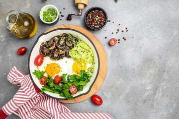 Wall Mural - Closeup of tasty fried eggs with avocado and mushrooms. Ketogenic diet. Low carb high fat breakfast. Healthy food concept. place for text, top view.