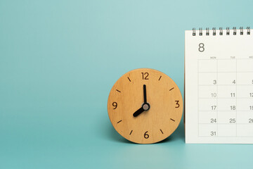 close up of calendar and clock on the green table background, planning for business meeting or travel planning concept