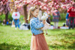 © Ekaterina Pokrovsky - preschooler girl in tutu skirt enjoying nice spring day in cherry blossom garden