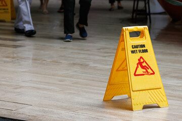 Wall Mural - wet floor sign with water drops on wet stone floor. plastic sign warning.