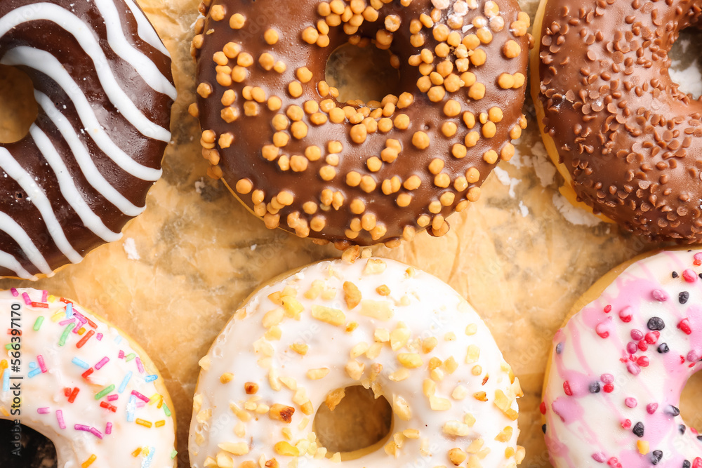 Sheet of baking paper with tasty donuts, closeup