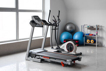 Poster - Interior of gym with modern treadmill, elliptical trainer and sport equipment