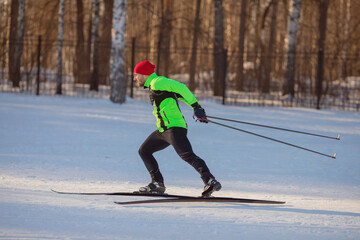 Wall Mural - Cross country skiing in winter on snowy track, sunset background, habits for healthy lifestyle