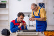 © Elnur - Two male repairmen repairing air-conditioner