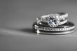 © gbertmartz - pair of silver diamond engagement ring jewelry his and hers wedding day ceremony still life close up with blurry background and white platform