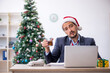 © Elnur - Young male employee celebrating Christmas at workplace