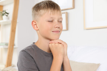 Wall Mural - Boy with clasped hands praying at home