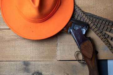 Wall Mural - hunting lay flat with an orange hat, shotgun and pheasant feathers