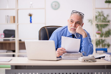 Wall Mural - Old male employee working in the office