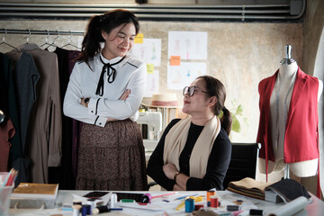 Wall Mural - Portrait of fashion team, Asian female designer and teen assistant in studio, arms crossed, look together smile, happy sewing works for dress design, professional boutique tailor SME entrepreneur.