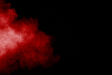 Wall Mural - Red powder explosion cloud on black background. Freeze motion of red color dust  particles splashing.