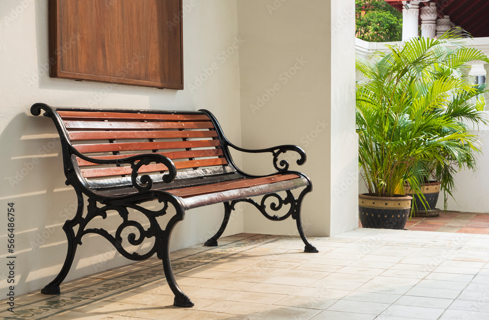 Blank vintage bench near white wall with green houseplant on terrace of ...
