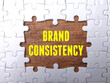 White puzzle with the word BRAND CONSISTENCY. Business concept.