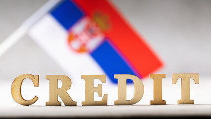 Text lined with wooden letters and the Serbian flag on an abstract background, a concept on the theme of the debt burden of the inhabitants of Serbia