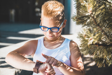 Poster - blond man in glasses looks at his watch on his hand