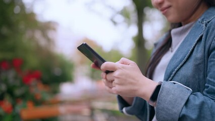 close up asia female using smartphone searching travel destination location map on application device platform,asian woman traveller using smartphone  in the park travel concept